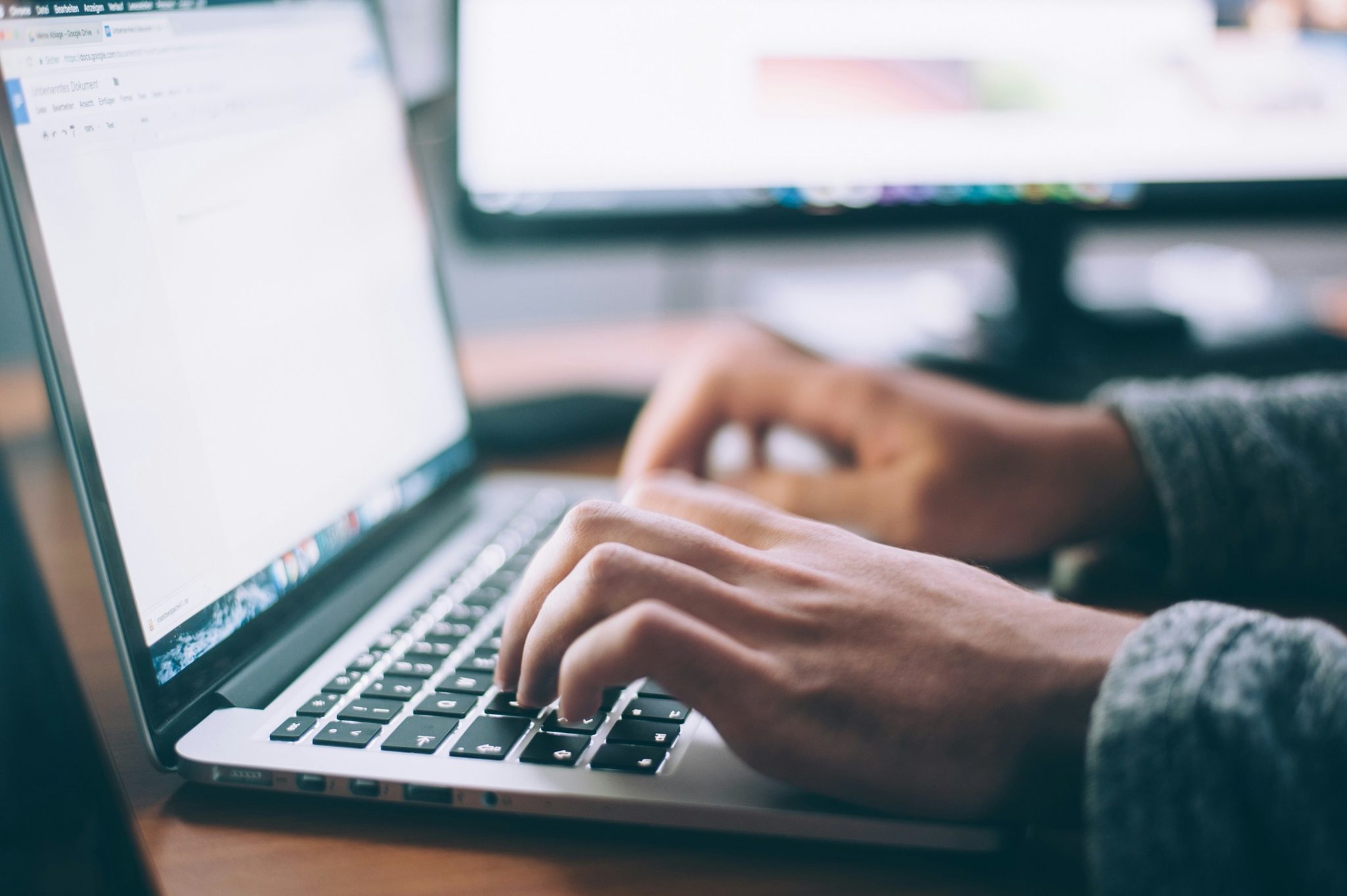 Hands typing an application on a laptop