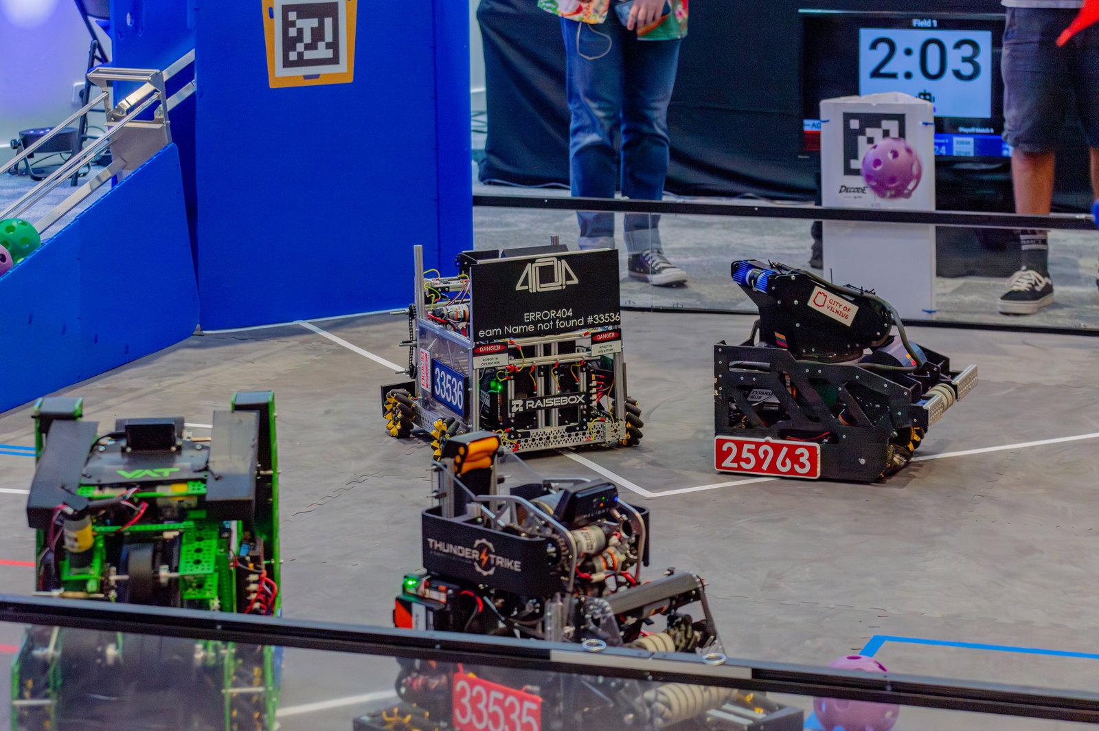 Four robots on the DECODE field mid-match, the goal at one end